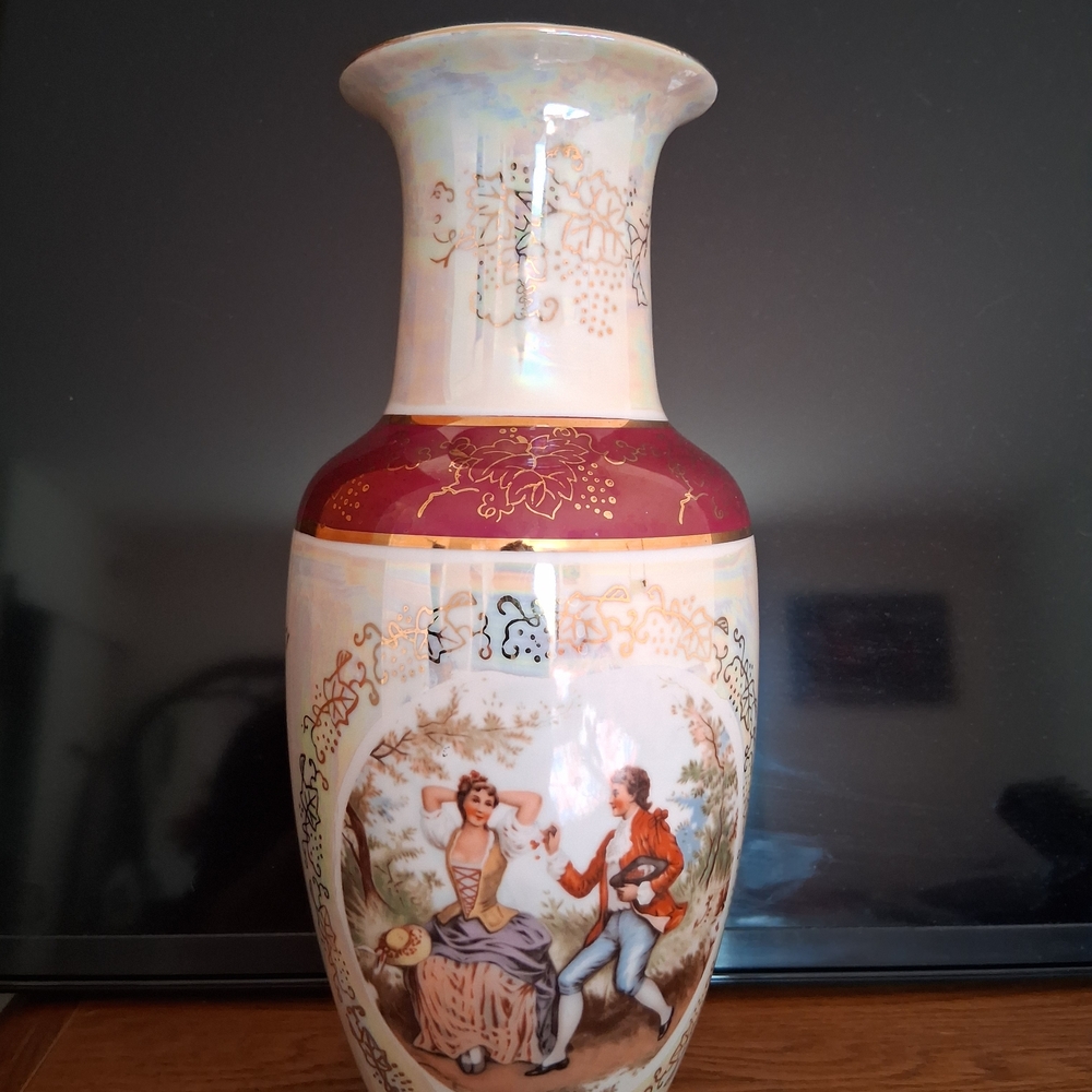 A vintage Japanese porcelain vase decorated with an image of a Victorian couple.
